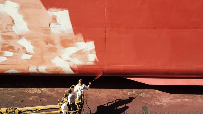 men painting ship hull