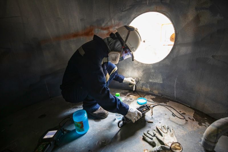 Confined space in silo with industrial worker inside.