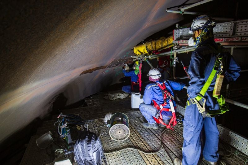 Industrial workers inside confined space.