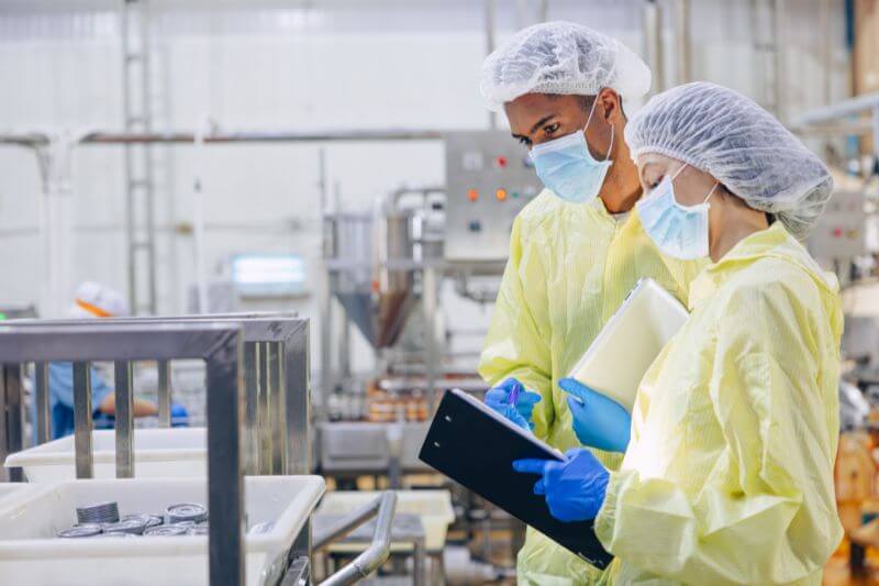 Auditors in food factory with clipboards.