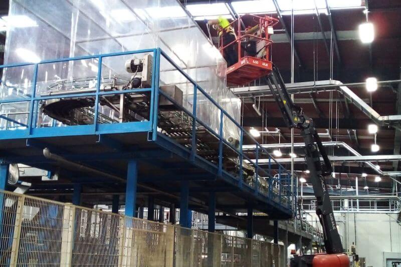 Industrial worker on scissor lift in large warehouse
