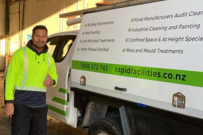 Rapid Facilities team member standing by company truck