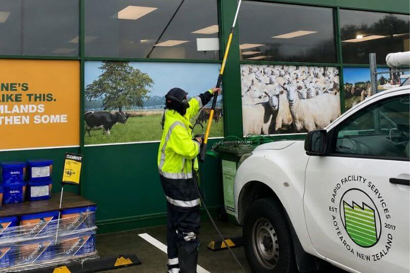 Rapid Facilities team member cleaning external building